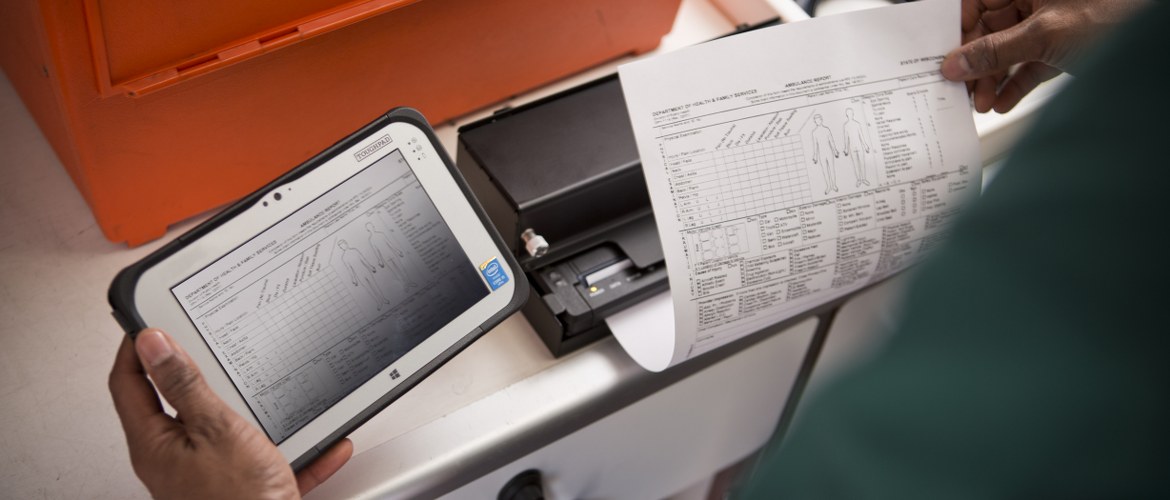 A healthcare paramedic is using the Brother PJ7 mobile printer to print out hospital patient pre-admissions from the ambulance via a tablet computer. 