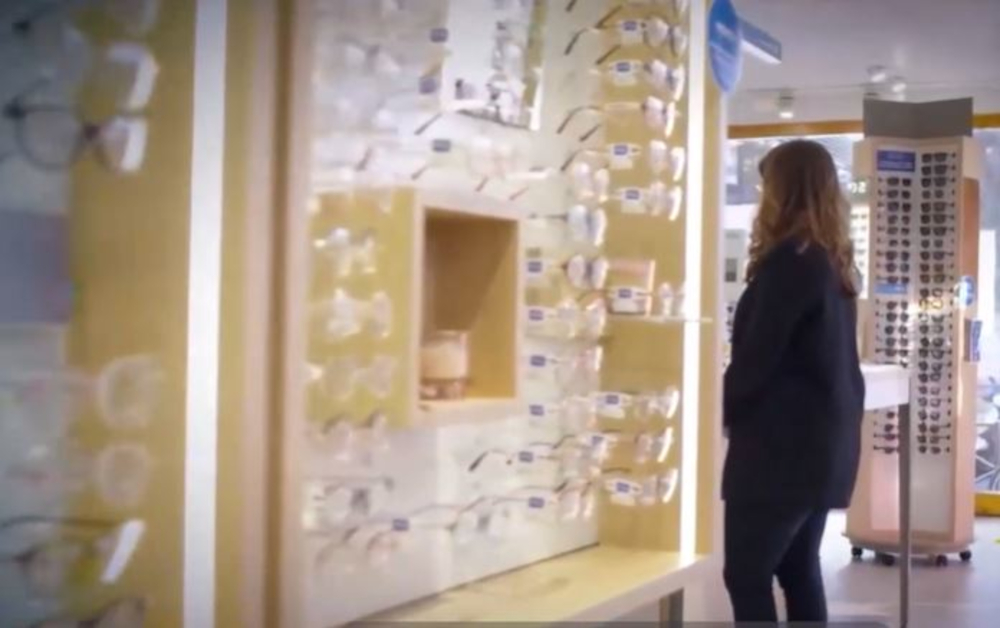 Optikkoliikkeen sisätilat, silmälaseja ja nainen