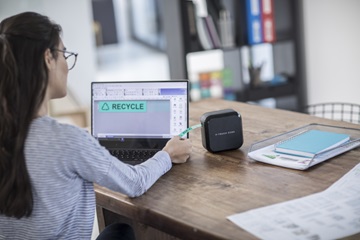 Nainen tulostaa tarroja CUBE Plus -tarratulostimella