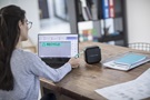 Nainen tulostaa läppärillä suunnittelemaansa tarraa CUBE-tarratulostimella